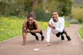 Happy young african american woman and guy doing push up exercise in park outdoor, free space Royalty Free Stock Photo