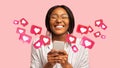 Happy young african american woman has romantic chat with hearts on phone, enjoys message, good news