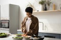Happy young African American woman preparing food in kitchen. Royalty Free Stock Photo