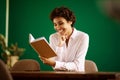 Happy young african american woman reading book at home Royalty Free Stock Photo