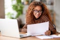 Happy young african american woman smiling   while working remotely studying online from home Royalty Free Stock Photo