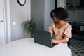 Happy young African American woman using laptop computer, chatting with friends online in social network, answering Royalty Free Stock Photo