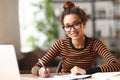 Happy young african american woman working online on laptop or female student studying online at home Royalty Free Stock Photo