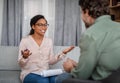 Happy young african american woman doctor in glasses talking with patient at meeting Royalty Free Stock Photo