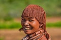 Happy young African female in a traditional headdress and body paint from the Ethiopian Hamer tribe