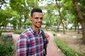 Happy young African hipster man with backpack at the park outdoors Royalty Free Stock Photo