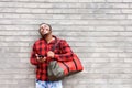 Happy young african man laughing with mobile phone and bag Royalty Free Stock Photo