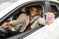 Happy young african man showing his driver's license from open car window Royalty Free Stock Photo