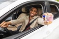 Happy young african man showing his driver's license from open car window Royalty Free Stock Photo