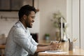 Happy young african mixed race man using cellphone in office.