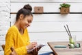 Happy young african woman sitting at cafe and writing notes Royalty Free Stock Photo