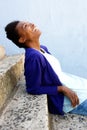 Happy young african woman sitting outdoors on steps Royalty Free Stock Photo