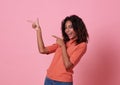 Happy young african woman standing with her finger pointing isolated over pink banner background with copy space Royalty Free Stock Photo