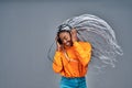 Happy young Afro American lady relaxed with great song, has broad smile, touches headphones, listens music, dressed in yellow Royalty Free Stock Photo