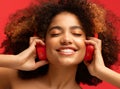 Happy young Afro American woman relaxed with great song, has broad smile, touches headphones, listens music Royalty Free Stock Photo