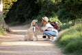 Happy young amateur photograph woman acariciating her dog in the park