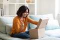 Happy young arab woman opening delivery box at home and looking inside Royalty Free Stock Photo