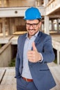 Young architect showing thumbs up on a construction site