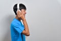 Happy young Asian boy teenager listening to music with his headphones with a copy space Royalty Free Stock Photo