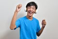 Happy young Asian boy teenager listening to music with his headphones Royalty Free Stock Photo
