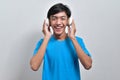 Happy young Asian boy teenager listening to music with his headphones Royalty Free Stock Photo