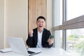 Happy young Asian business man in office looking at mobile phone, with emotion winner or win, financial stock sports betting Royalty Free Stock Photo