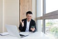 Happy young Asian business man in office looking at mobile phone, with emotion winner or win, financial stock sports betting Royalty Free Stock Photo