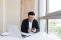 Happy young Asian business man in office looking at mobile phone, with emotion winner or win, financial stock sports betting. Royalty Free Stock Photo