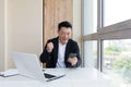 Happy young Asian business man in office looking at mobile phone, with emotion winner or win, financial stock sports betting Royalty Free Stock Photo