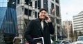 Happy young Asian business man walking on big city street making phone call. Royalty Free Stock Photo