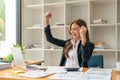 Happy young Asian business woman celebrate success at work in office looking at laptop excited about financial or Royalty Free Stock Photo