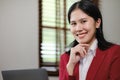 Happy young Asian business woman looking at camera welcoming client. Smiling woman executive manager, in the office Royalty Free Stock Photo