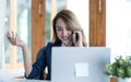 Happy young Asian business woman sitting smiling and talking on mobile phone in office. Royalty Free Stock Photo