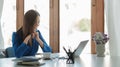 Happy young asian business woman using laptop computer to greeting partner during making video conference with her team Royalty Free Stock Photo