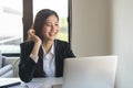 Young asian business woman waving hands to greeting partner during making video conference with her team Royalty Free Stock Photo