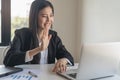 Young asian business woman waving hands to greeting partner during making video conference with her team Royalty Free Stock Photo