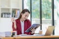 Happy young asian businesswoman celebrating success with arms raised in front of laptop with excitement at office Royalty Free Stock Photo