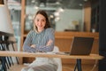 Happy young asian businesswoman celebrating success with arms raised in front of laptop with excitement at office Royalty Free Stock Photo