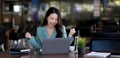 Happy young asian businesswoman sitting on her workplace in the office. Young woman working at laptop in the office Royalty Free Stock Photo