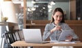 Happy young asian businesswoman sitting on her workplace in the office. Young woman working at laptop in the office Royalty Free Stock Photo