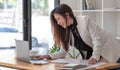 Happy young Asian businesswoman standing using laptop computer at office. Royalty Free Stock Photo