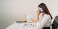 Happy young asian businesswoman talk on the mobile phone while sitting at working place in office Royalty Free Stock Photo