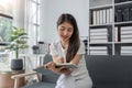 Happy young Asian businesswoman working and taking notes in home Royalty Free Stock Photo