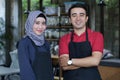 Happy young asian couple cafe owner in front of coffee shop smiling. portrait of two waiters at restaurant Royalty Free Stock Photo