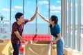 Happy young asian couple give high five to each other and smiling celebrate relocating into new home on moving day Royalty Free Stock Photo