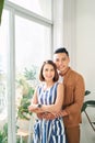Happy young Asian couple looking through window at home Royalty Free Stock Photo