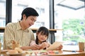 Happy young Asian daughter is enjoying a painting workshop with her father Royalty Free Stock Photo