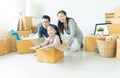 Happy young Asian family of three having fun moving with cardboard boxes in new house at moving day. Moving house day and express