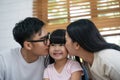 Happy young asian father and mother are kissing her daughter`s cheek. Royalty Free Stock Photo