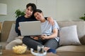 A happy Asian gay man is hugging his boyfriend while watching a movie on a couch together Royalty Free Stock Photo